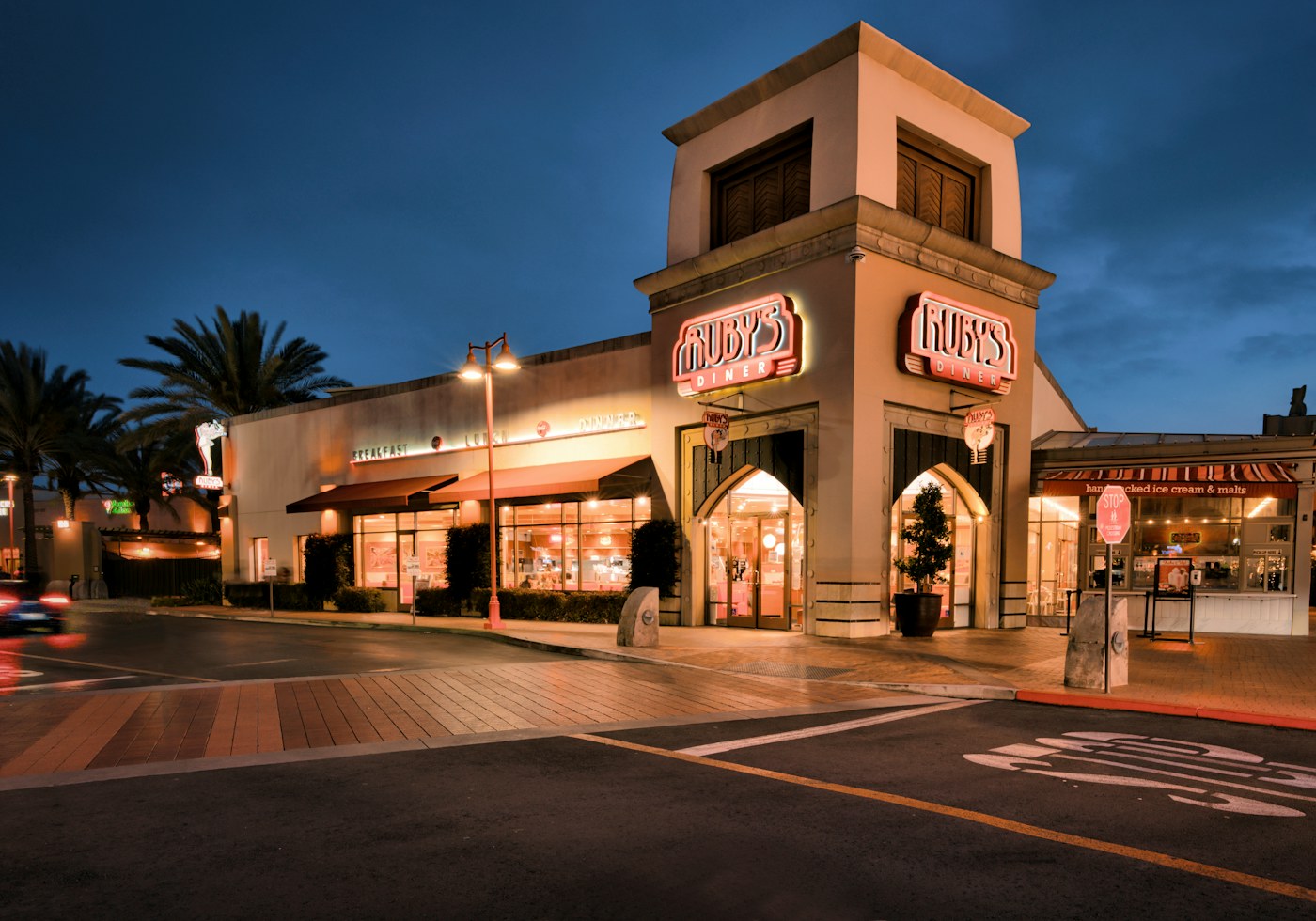 Commercial storefronts and a marked street frontage at dusk