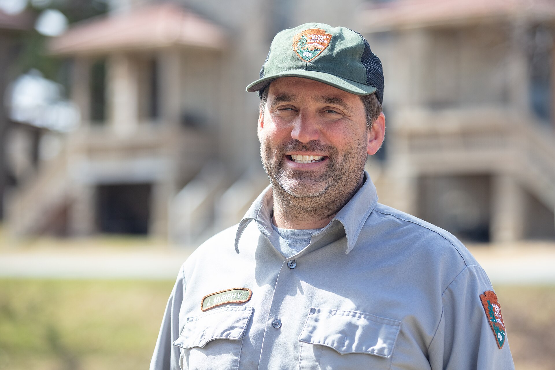Smiling U.S. facilities manager in work uniform outside a service building